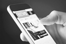 A hand holds a mobile phone scrolling through a screen titled news. An image with text below is seen on the screen.