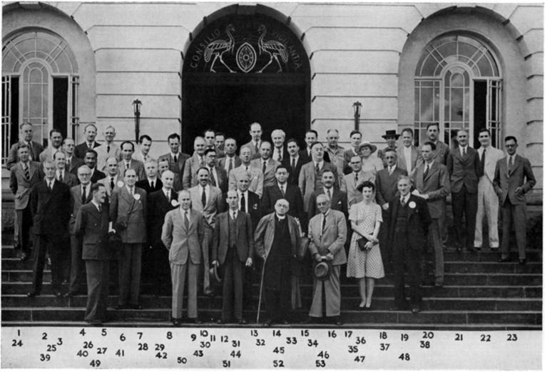 A photograph showing a group of people stood on the steps in front of an ornate building